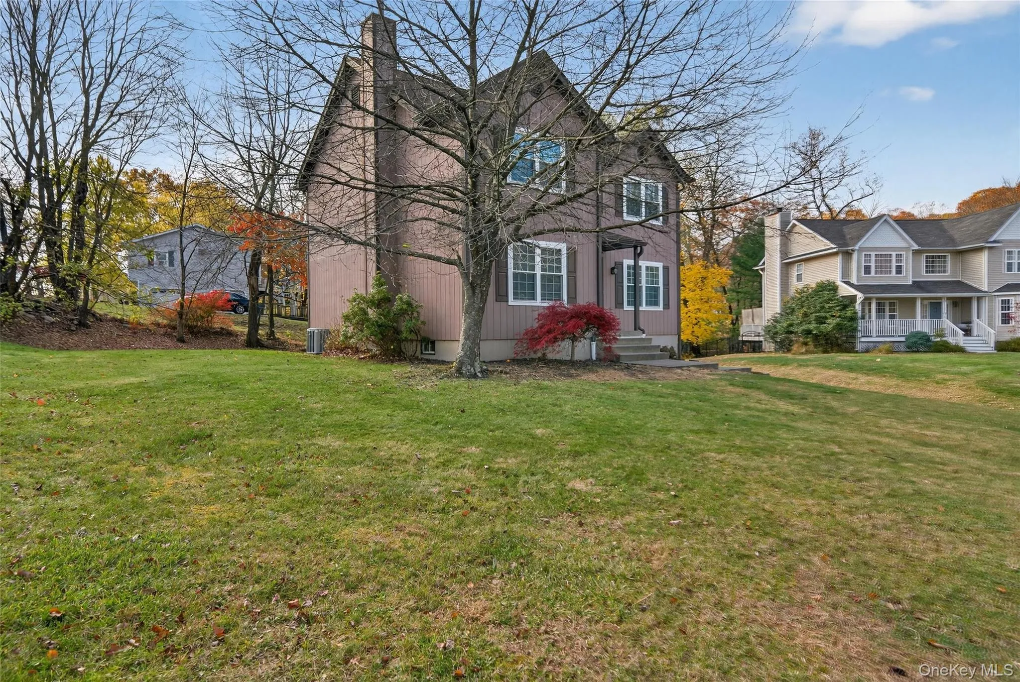Traditional home featuring a front lawn and a chimney Traditional home featuring a front lawn and a chimney