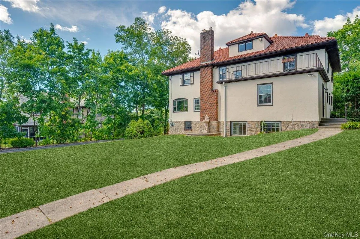 View of side of property with stucco siding, a chimney, and a lawn View of side of property with stucco siding, a chimney, and a lawn