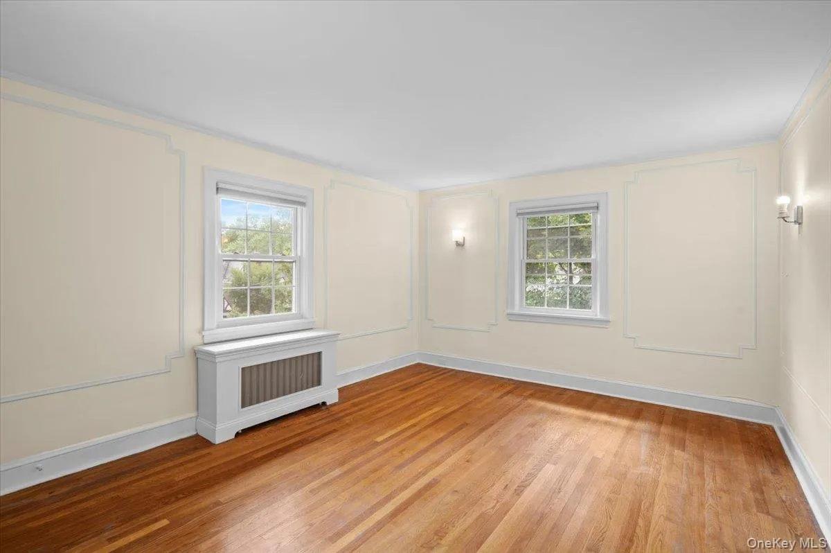 Unfurnished room with radiator and light wood-style floors Unfurnished room with radiator and light wood-style floors
