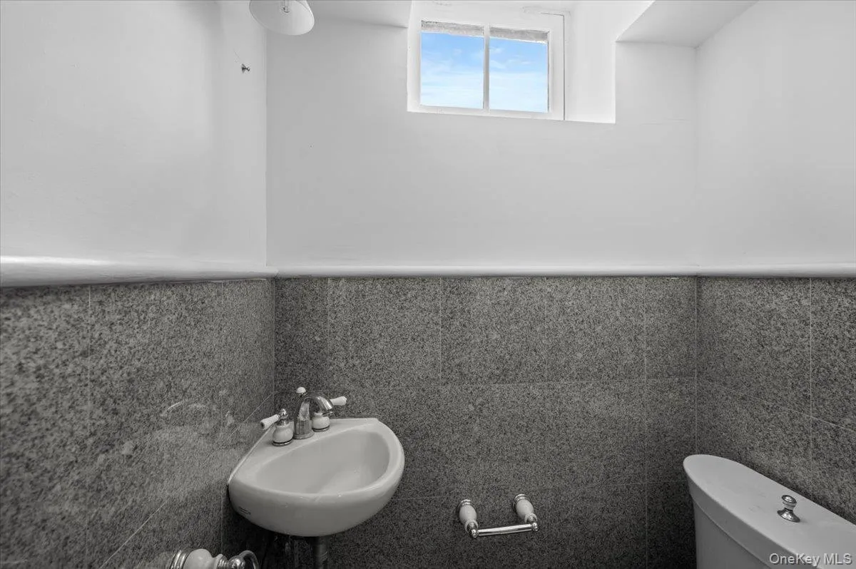 Bathroom with tile walls and a wainscoted wall Bathroom with tile walls and a wainscoted wall