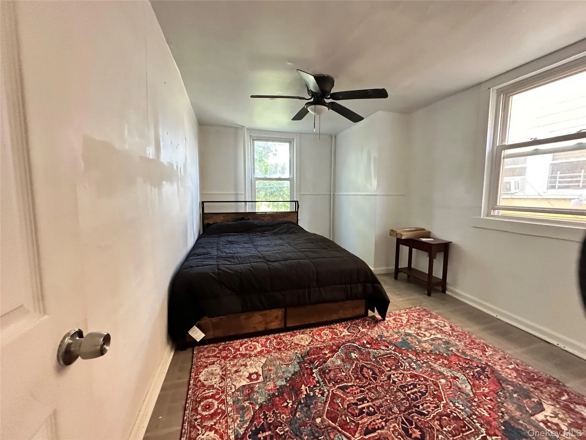 Bedroom with wood finished floors, multiple windows, and a ceiling fan Bedroom with wood finished floors, multiple windows, and a ceiling fan