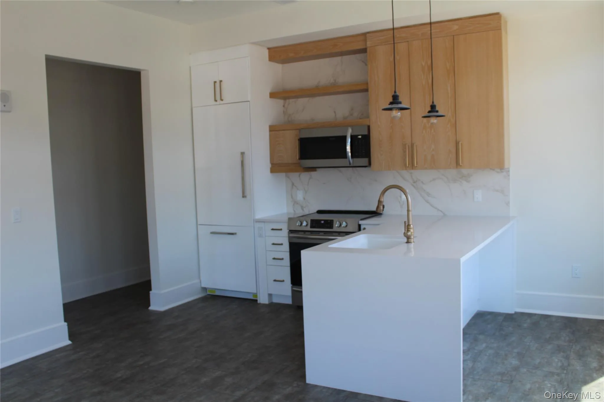 Kitchen featuring open shelves, tasteful backsplash, a peninsula, appliances with stainless steel finishes, and pendant lighting Kitchen featuring open shelves, tasteful backsplash, a peninsula, appliances with stainless steel finishes, and pendant lighting