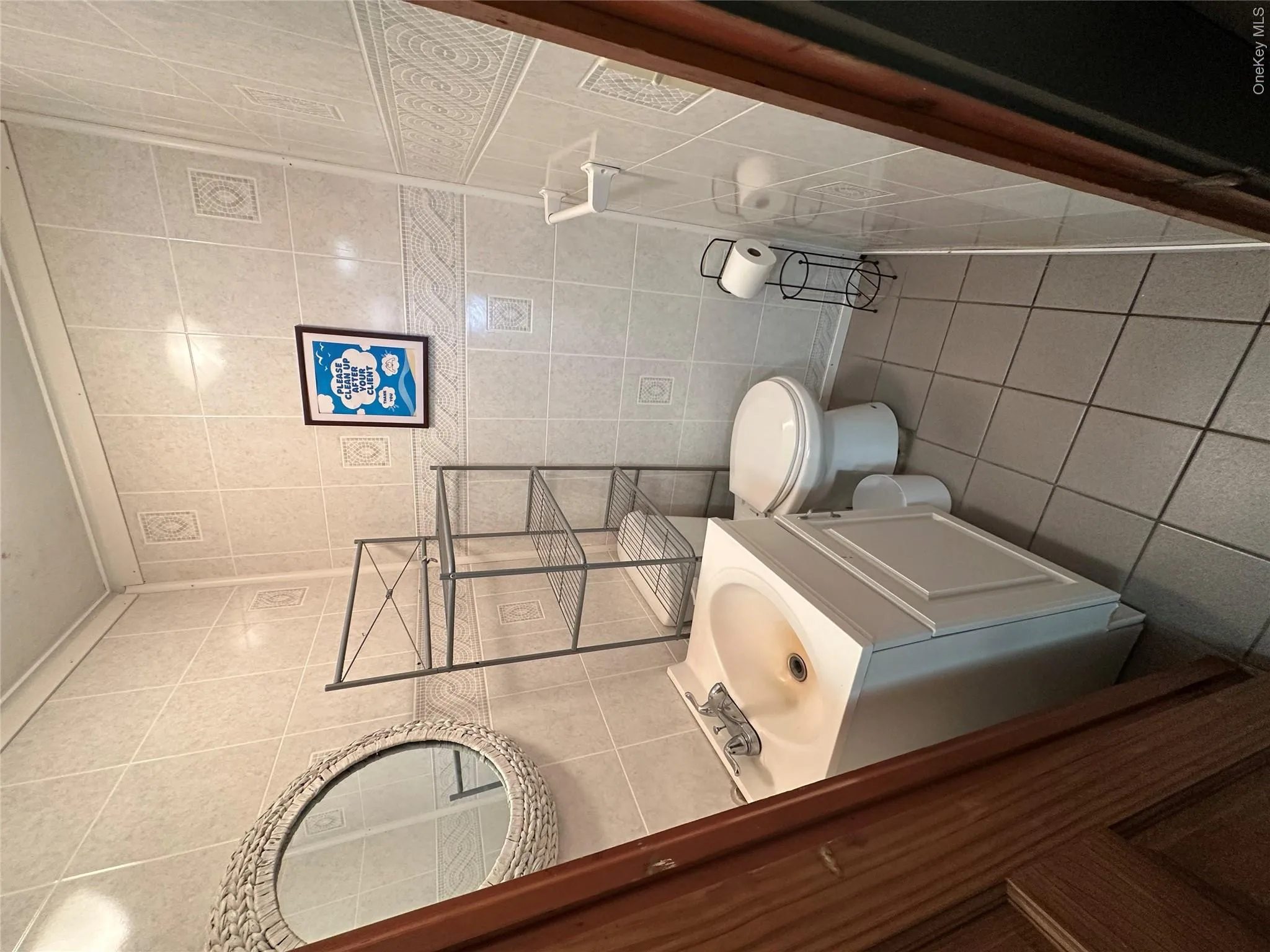 Half bathroom featuring tile walls, tile patterned floors, and vanity Half bathroom featuring tile walls, tile patterned floors, and vanity