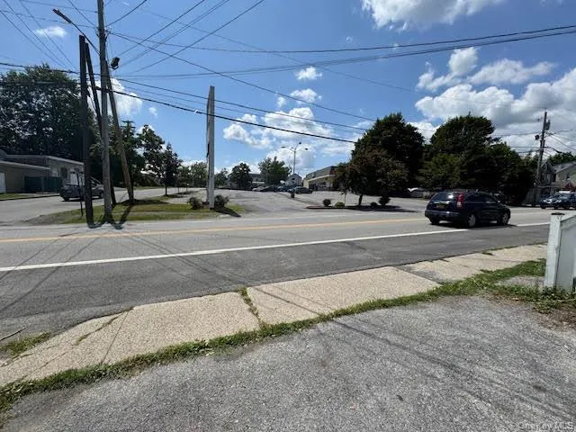 View of asphalt road featuring sidewalks and street lights View of asphalt road featuring sidewalks and street lights