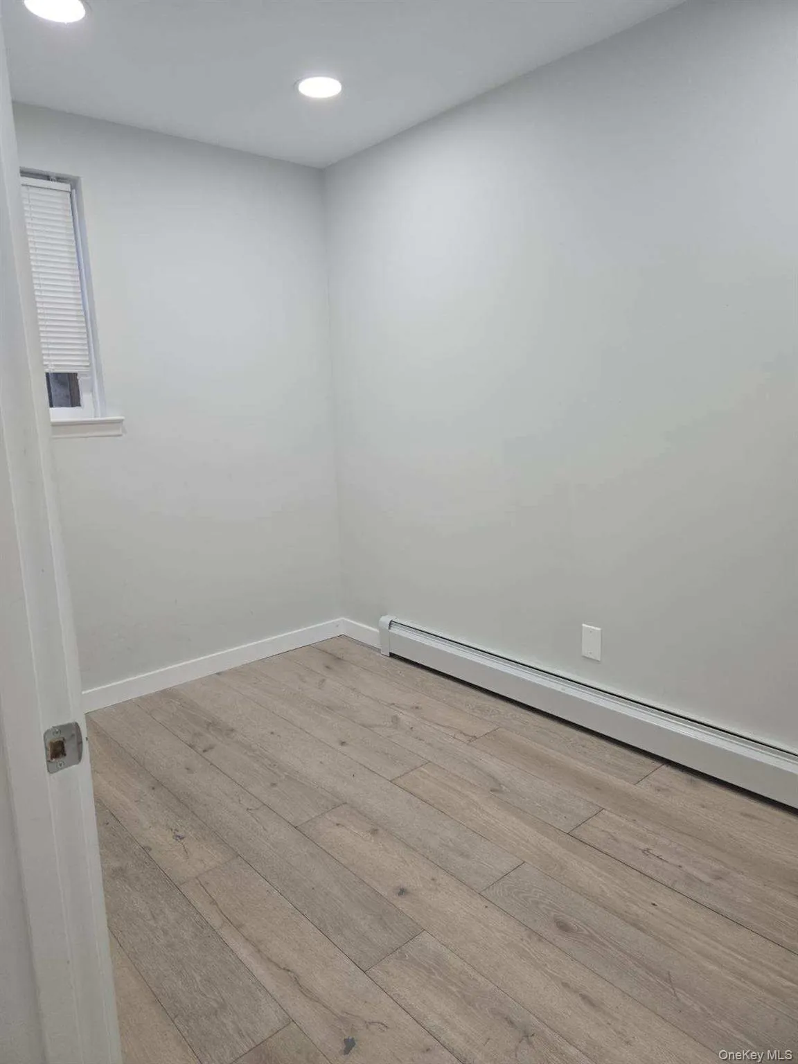 Unfurnished room featuring baseboard heating, light wood-style flooring, and recessed lighting Unfurnished room featuring baseboard heating, light wood-style flooring, and recessed lighting