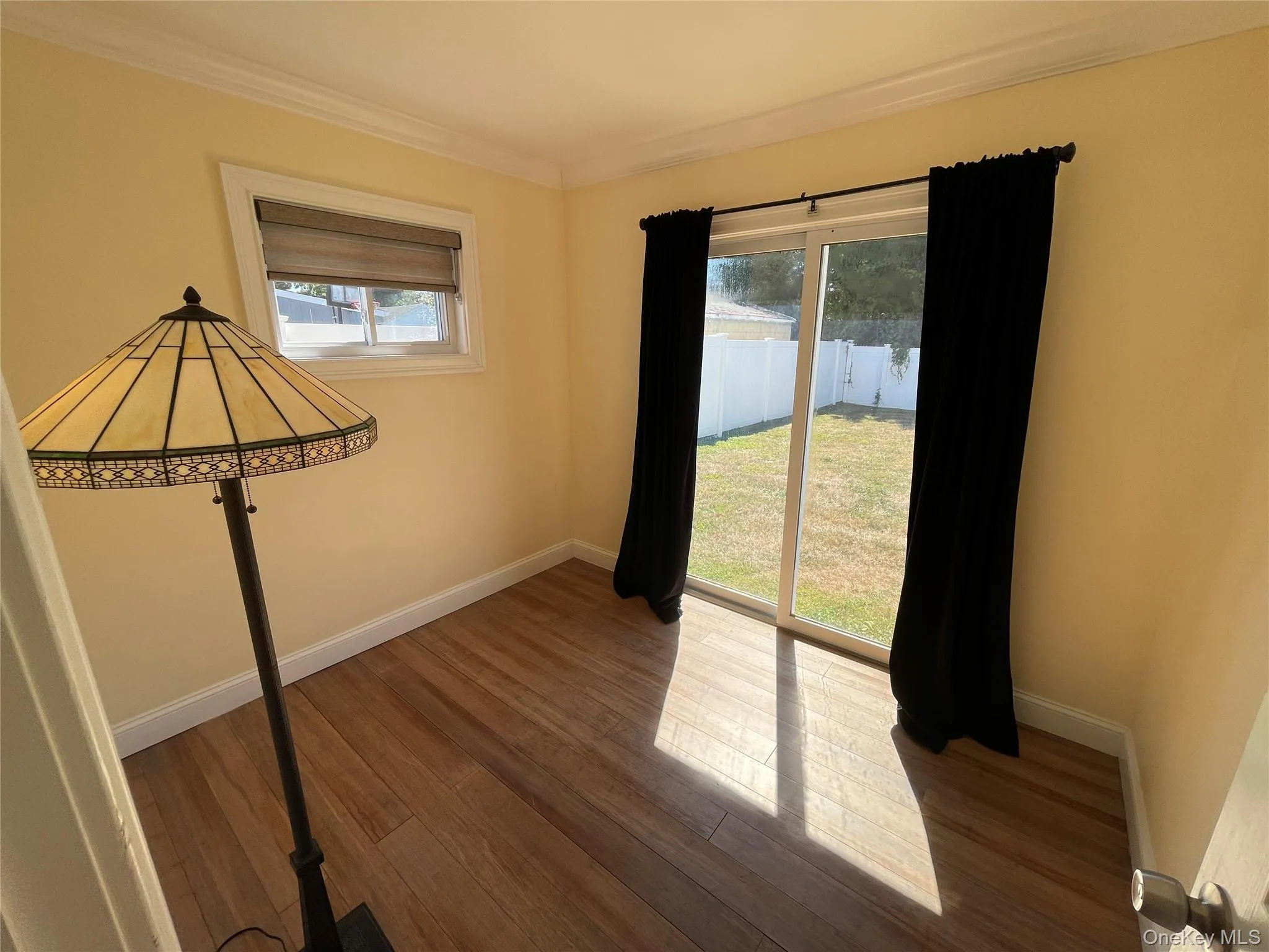 Unfurnished room featuring wood finished floors and crown molding Unfurnished room featuring wood finished floors and crown molding