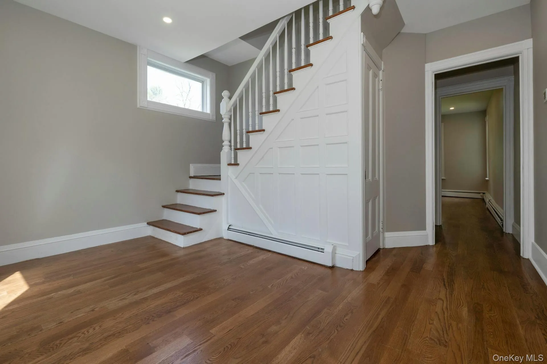 Staircase featuring a baseboard heating unit, wood finished floors, and recessed lighting Staircase featuring a baseboard heating unit, wood finished floors, and recessed lighting