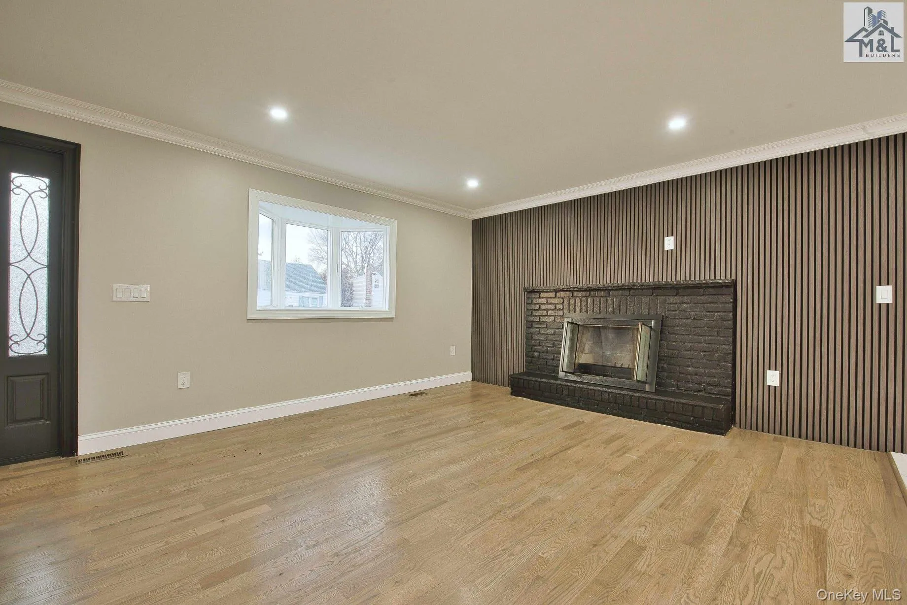 Unfurnished living room with crown molding, wooden walls, a fireplace, light wood-style floors, and recessed lighting Unfurnished living room with crown molding, wooden walls, a fireplace, light wood-style floors, and recessed lighting