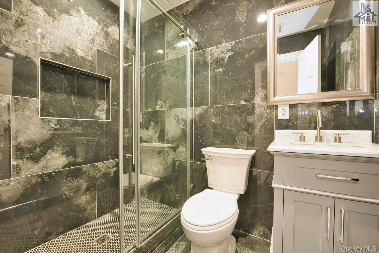 Full bath with tile walls, vanity, and a shower stall Full bath with tile walls, vanity, and a shower stall