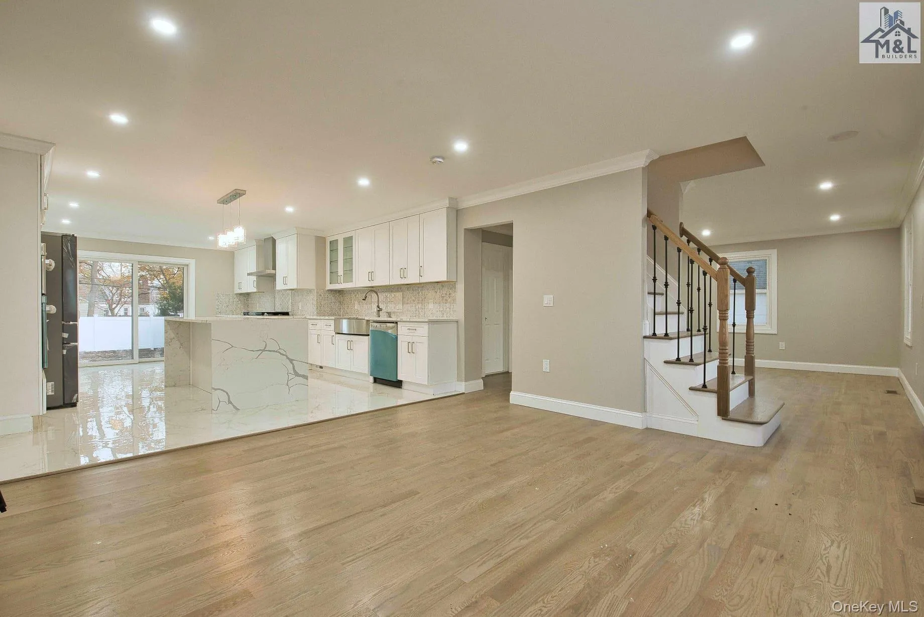Unfurnished living room with light wood finished floors, recessed lighting, ornamental molding, stairs, and a chandelier Unfurnished living room with light wood finished floors, recessed lighting, ornamental molding, stairs, and a chandelier
