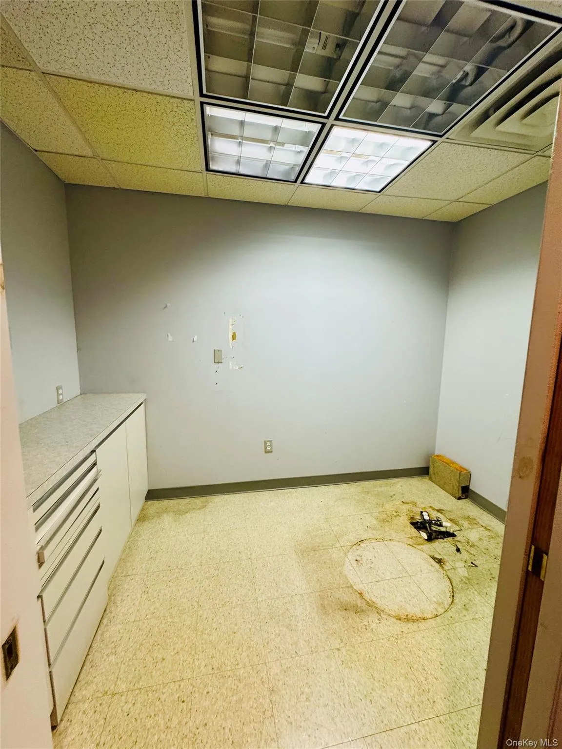 Empty room featuring light flooring and a drop ceiling Empty room featuring light flooring and a drop ceiling
