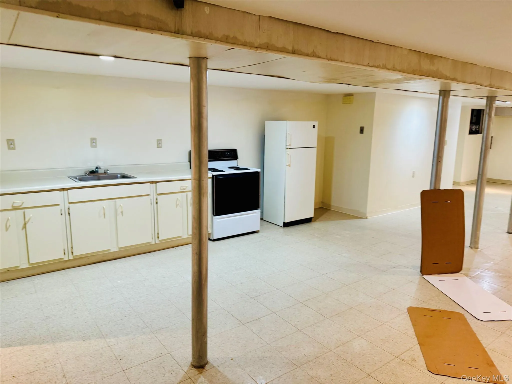 Finished basement featuring light floors and freestanding refrigerator Finished basement featuring light floors and freestanding refrigerator