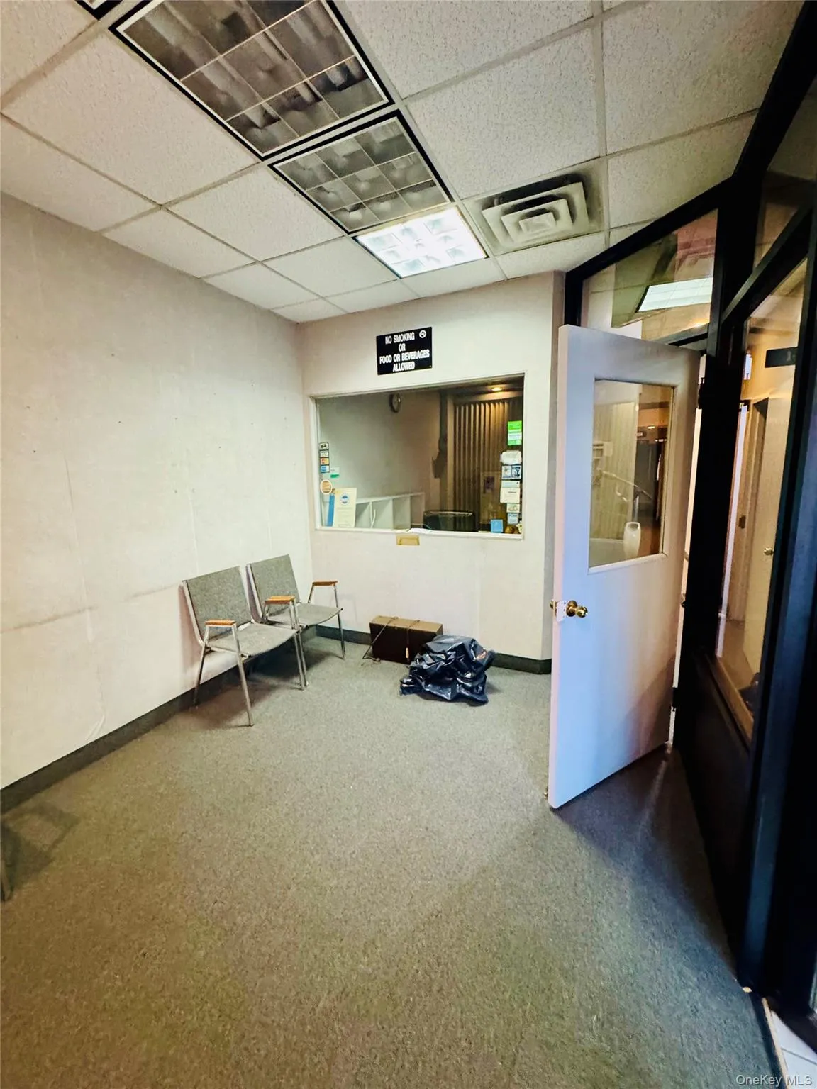 Sitting room with a drop ceiling and carpet floors Sitting room with a drop ceiling and carpet floors