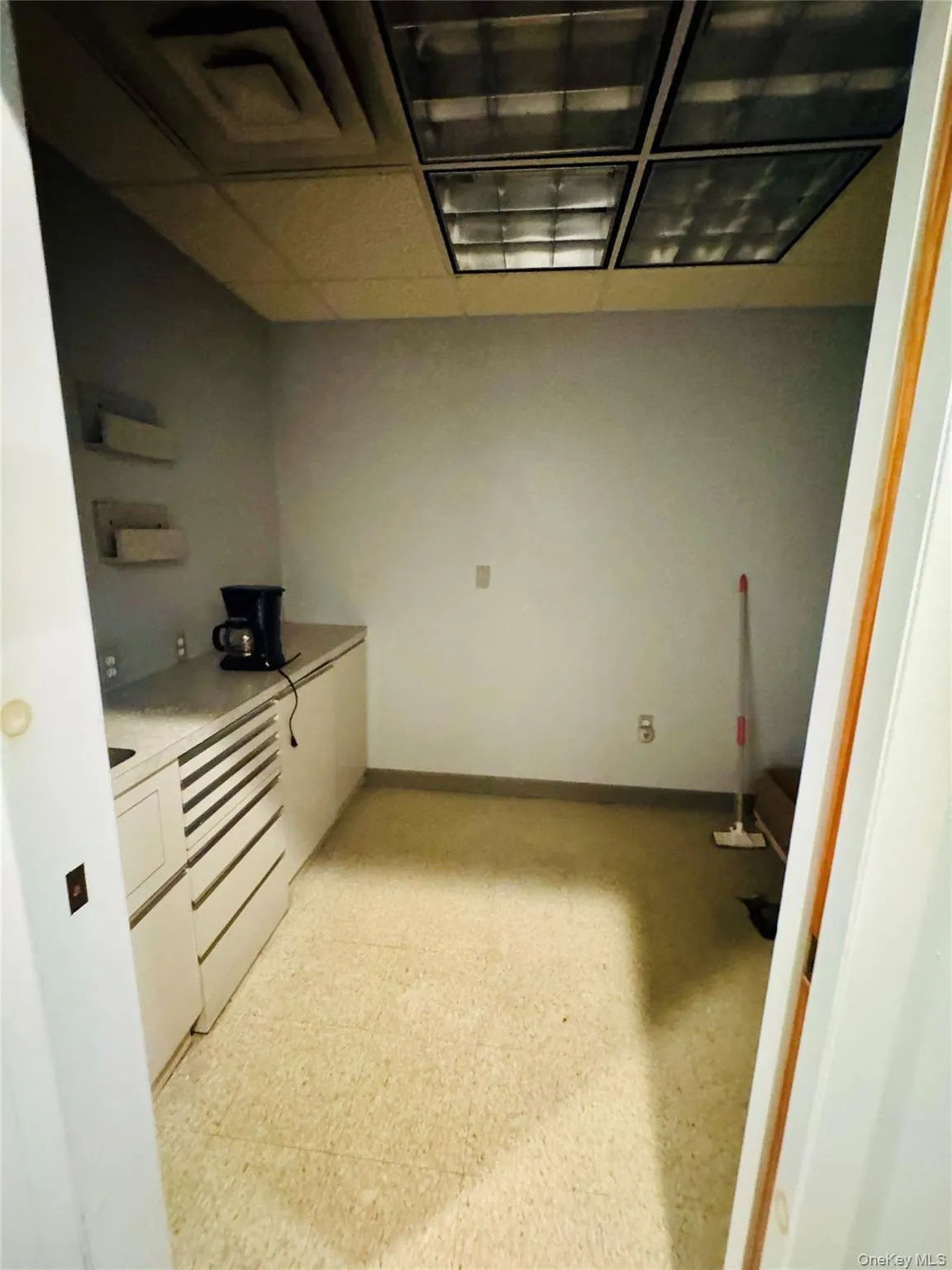 Kitchen featuring light countertops, white cabinets, and light flooring Kitchen featuring light countertops, white cabinets, and light flooring