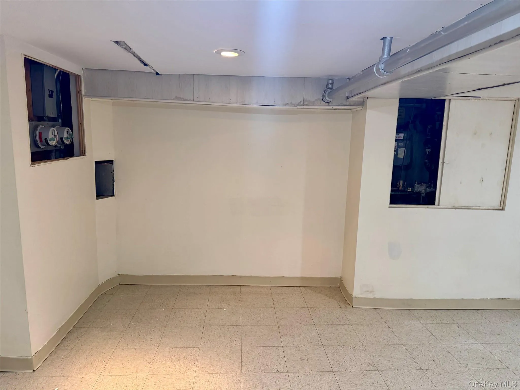 Basement featuring light floors and electric panel Basement featuring light floors and electric panel