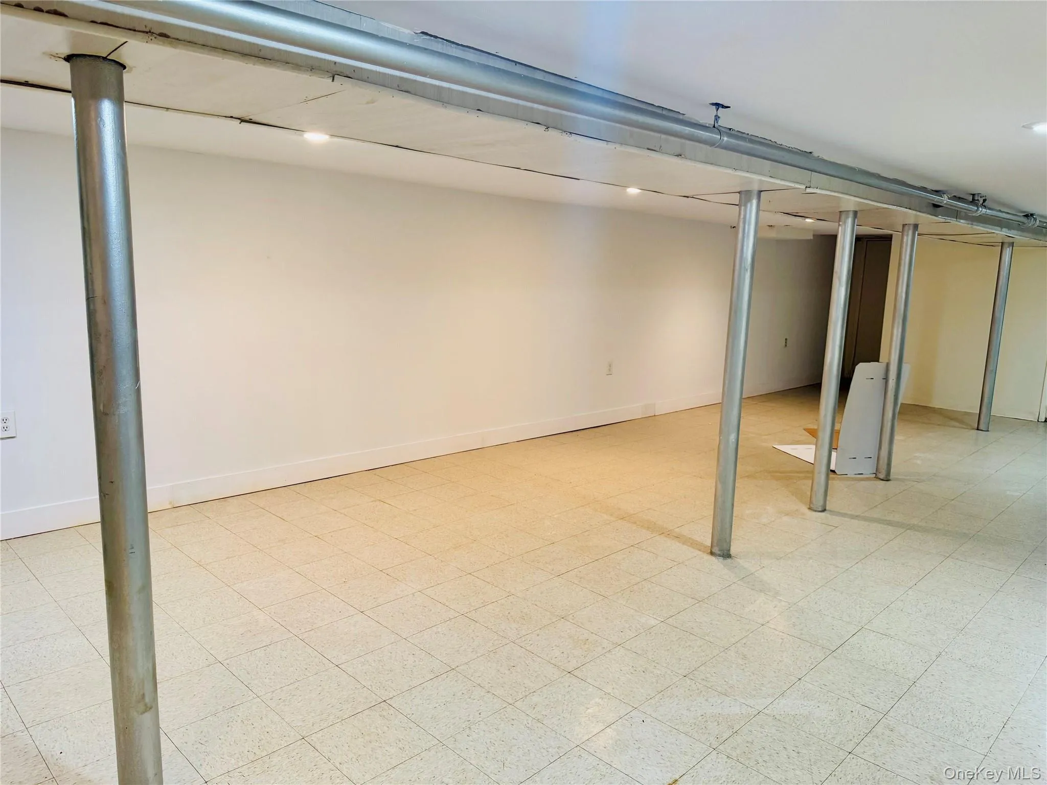 Finished basement featuring light floors and baseboards Finished basement featuring light floors and baseboards