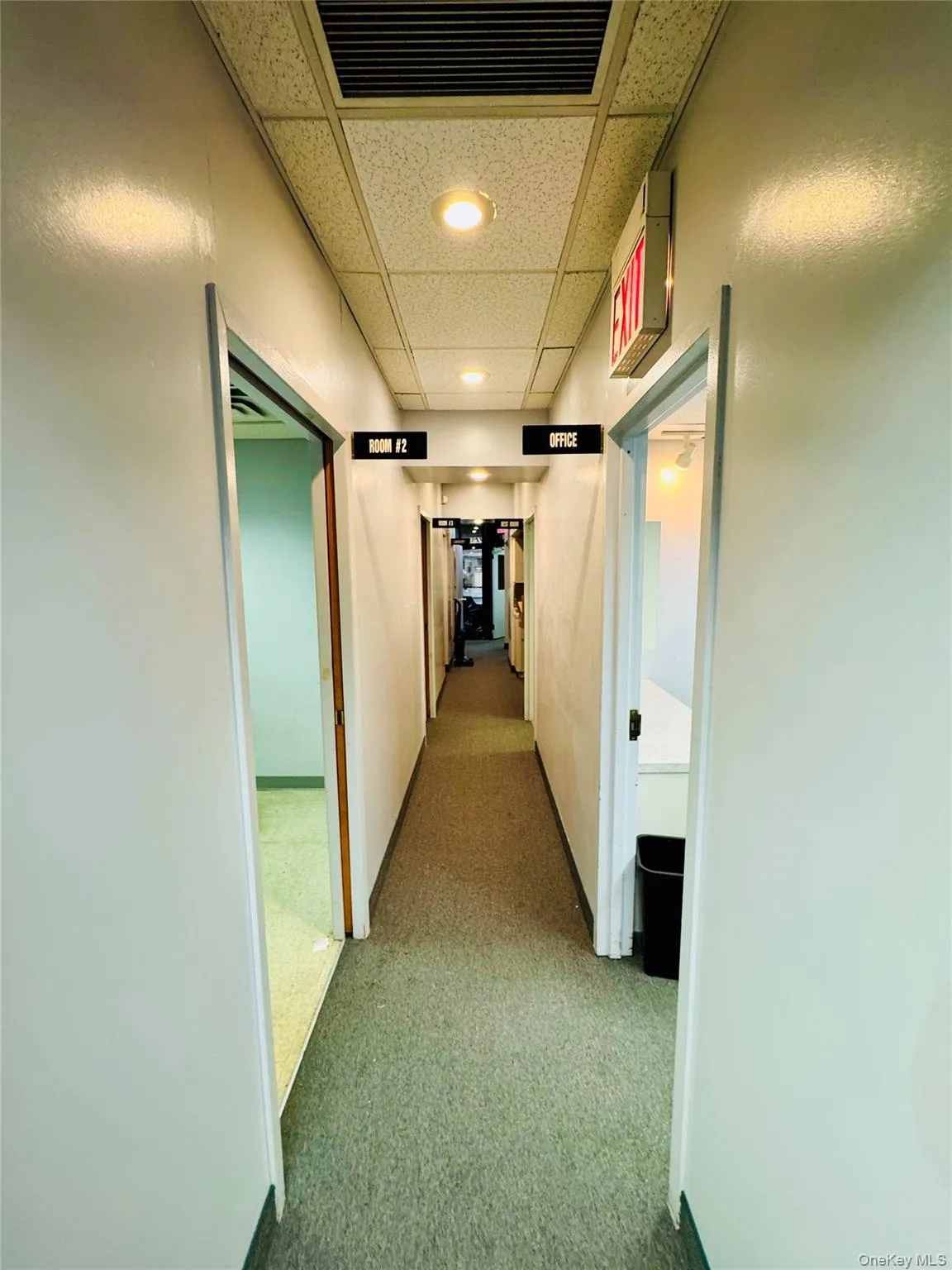 Hall with a paneled ceiling and carpet flooring Hall with a paneled ceiling and carpet flooring