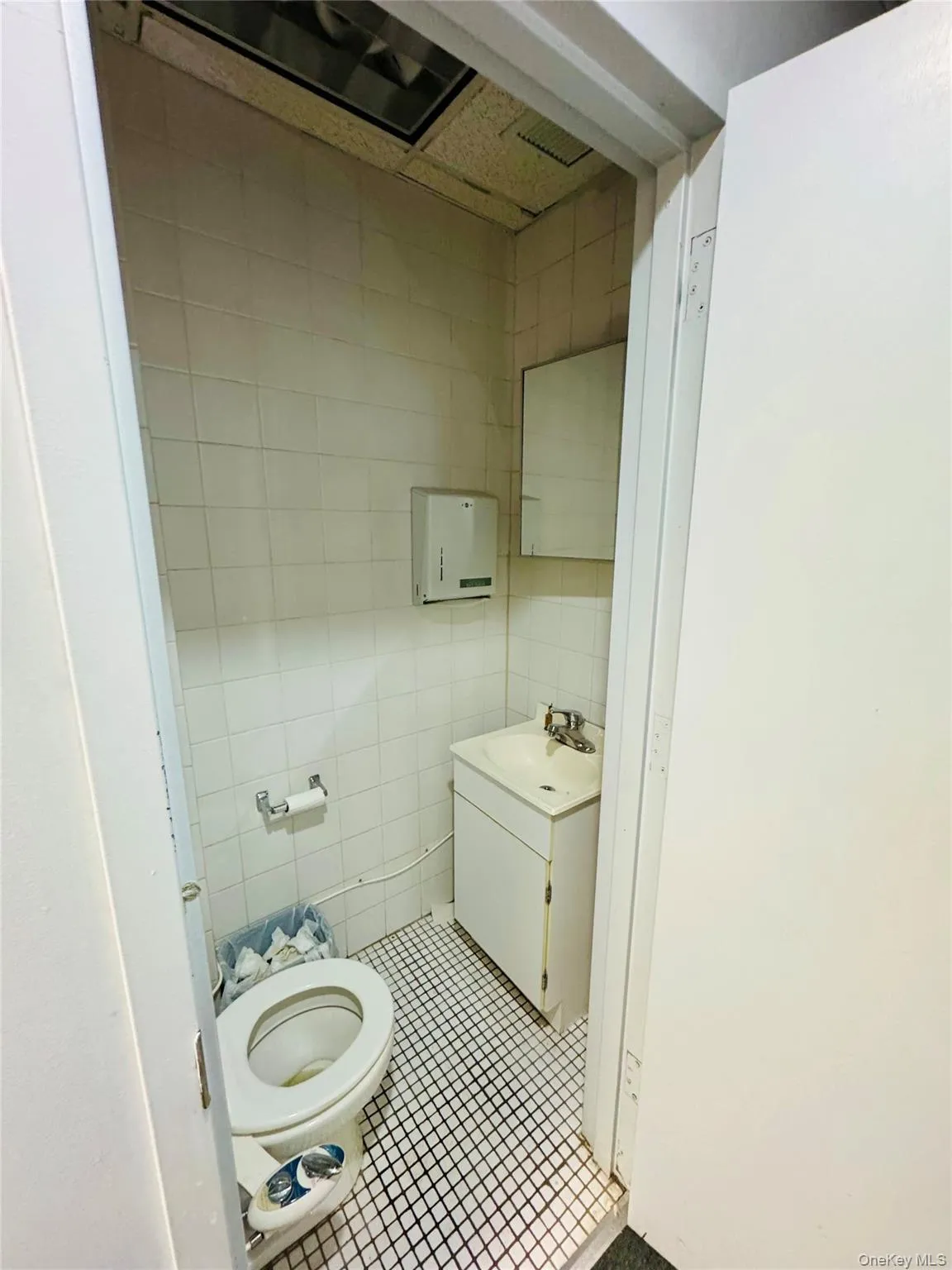 Bathroom with tile patterned floors, vanity, and tile walls Bathroom with tile patterned floors, vanity, and tile walls