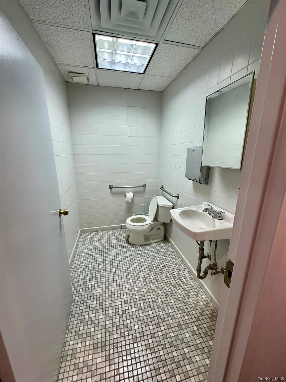 Bathroom with a paneled ceiling, tile patterned flooring, and tile walls Bathroom with a paneled ceiling, tile patterned flooring, and tile walls