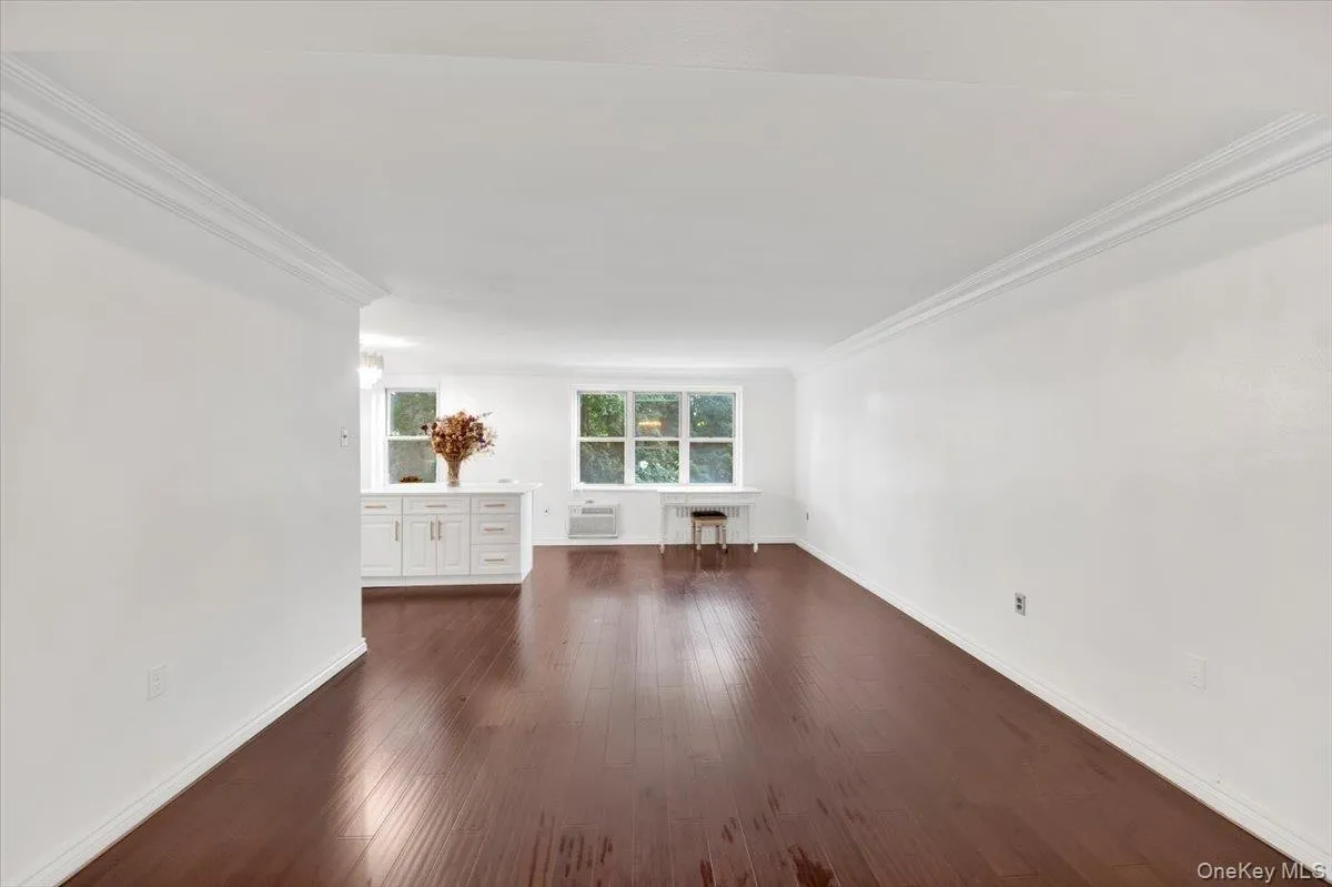 Spare room with dark wood-type flooring and ornamental molding Spare room with dark wood-type flooring and ornamental molding