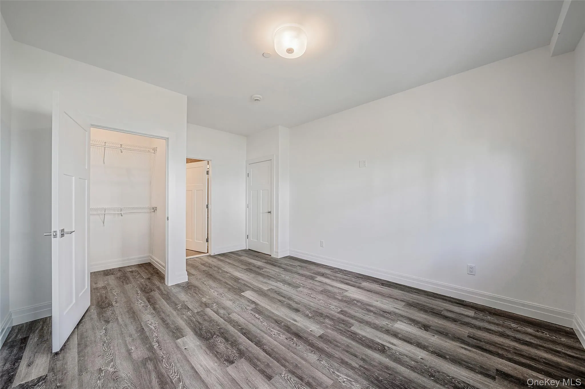 Unfurnished bedroom with wood finished floors and a closet Unfurnished bedroom with wood finished floors and a closet