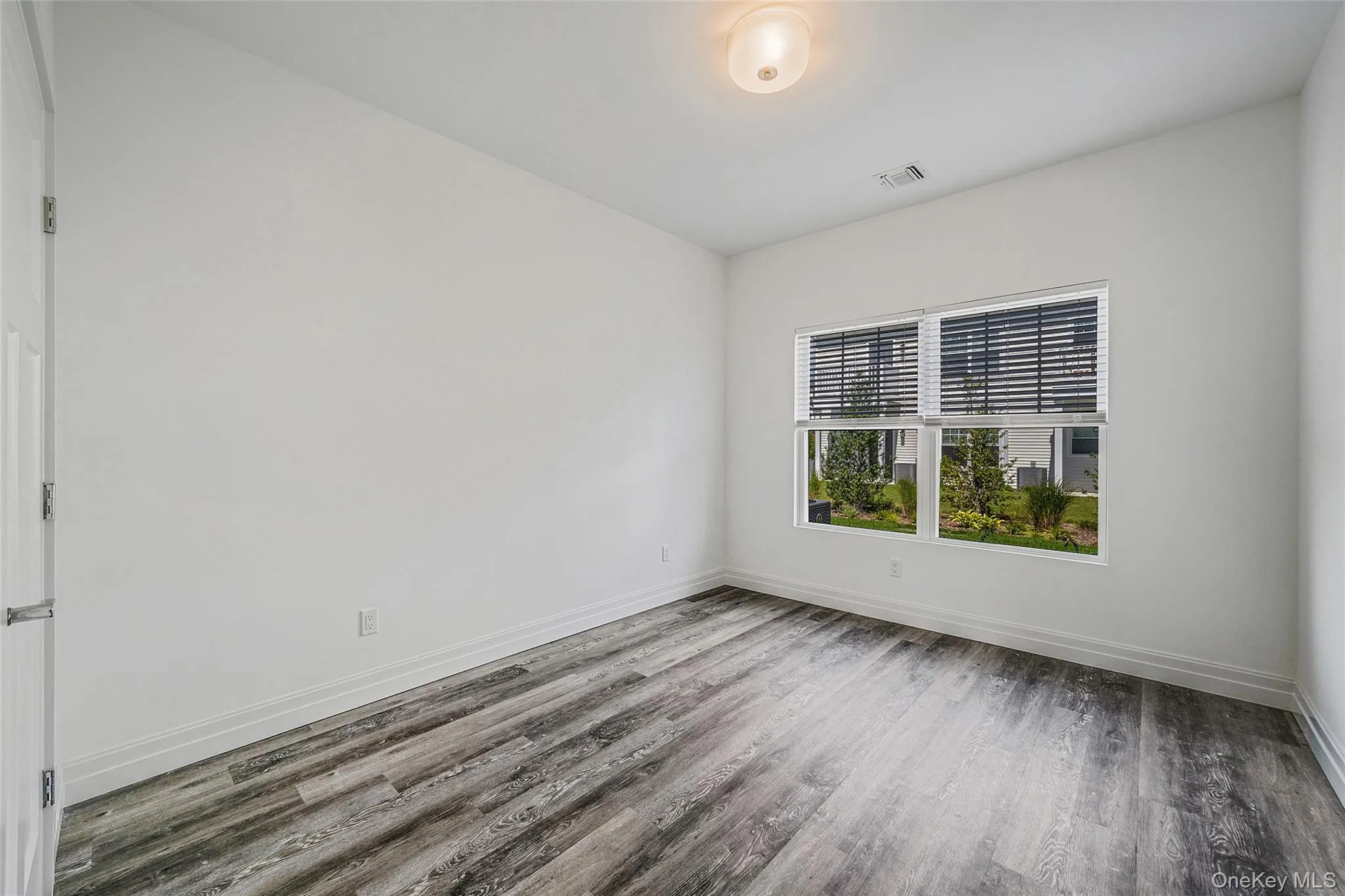 Spare room with wood finished floors and baseboards Spare room with wood finished floors and baseboards