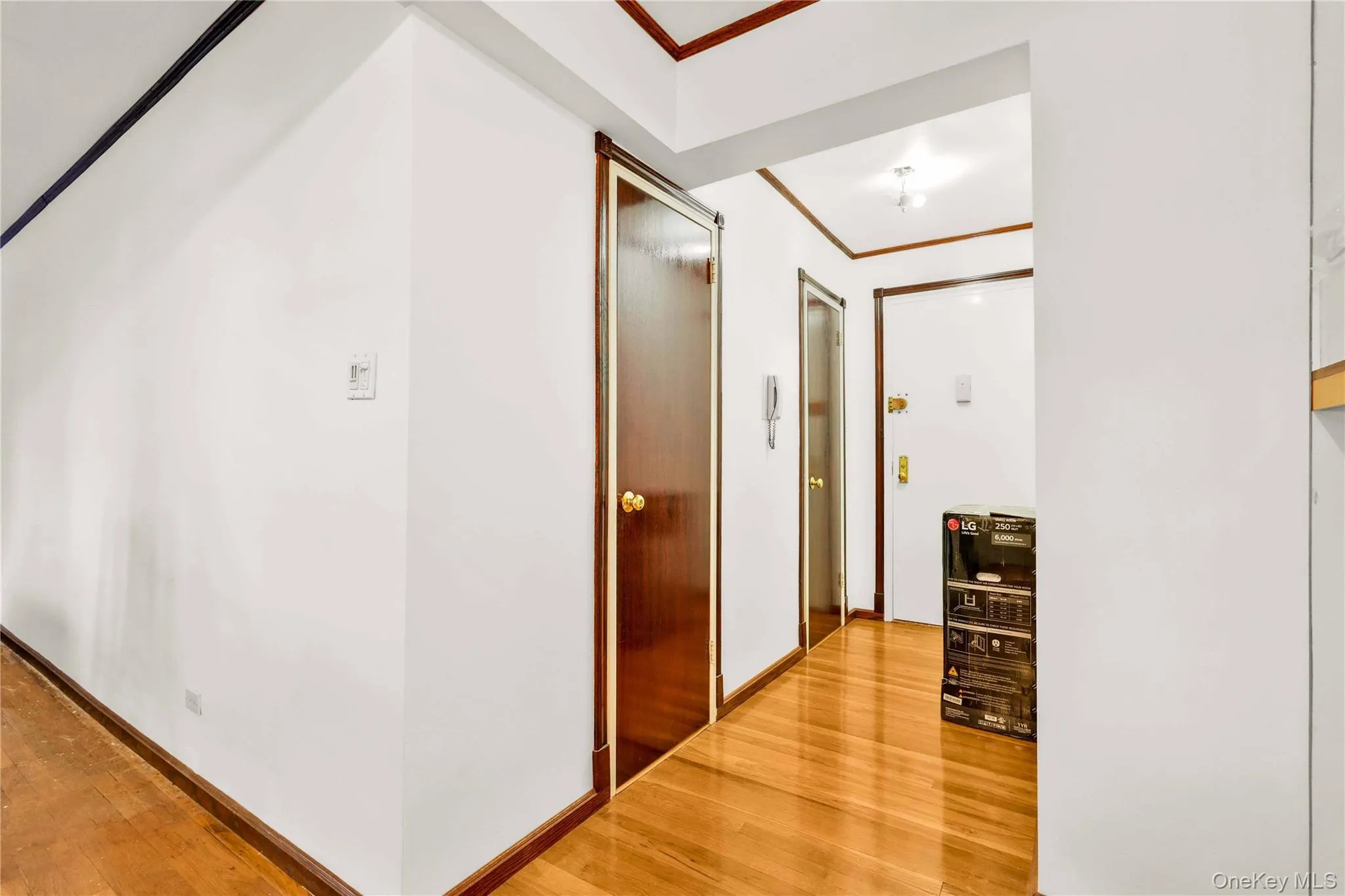Hall with light wood-style floors and ornamental molding Hall with light wood-style floors and ornamental molding