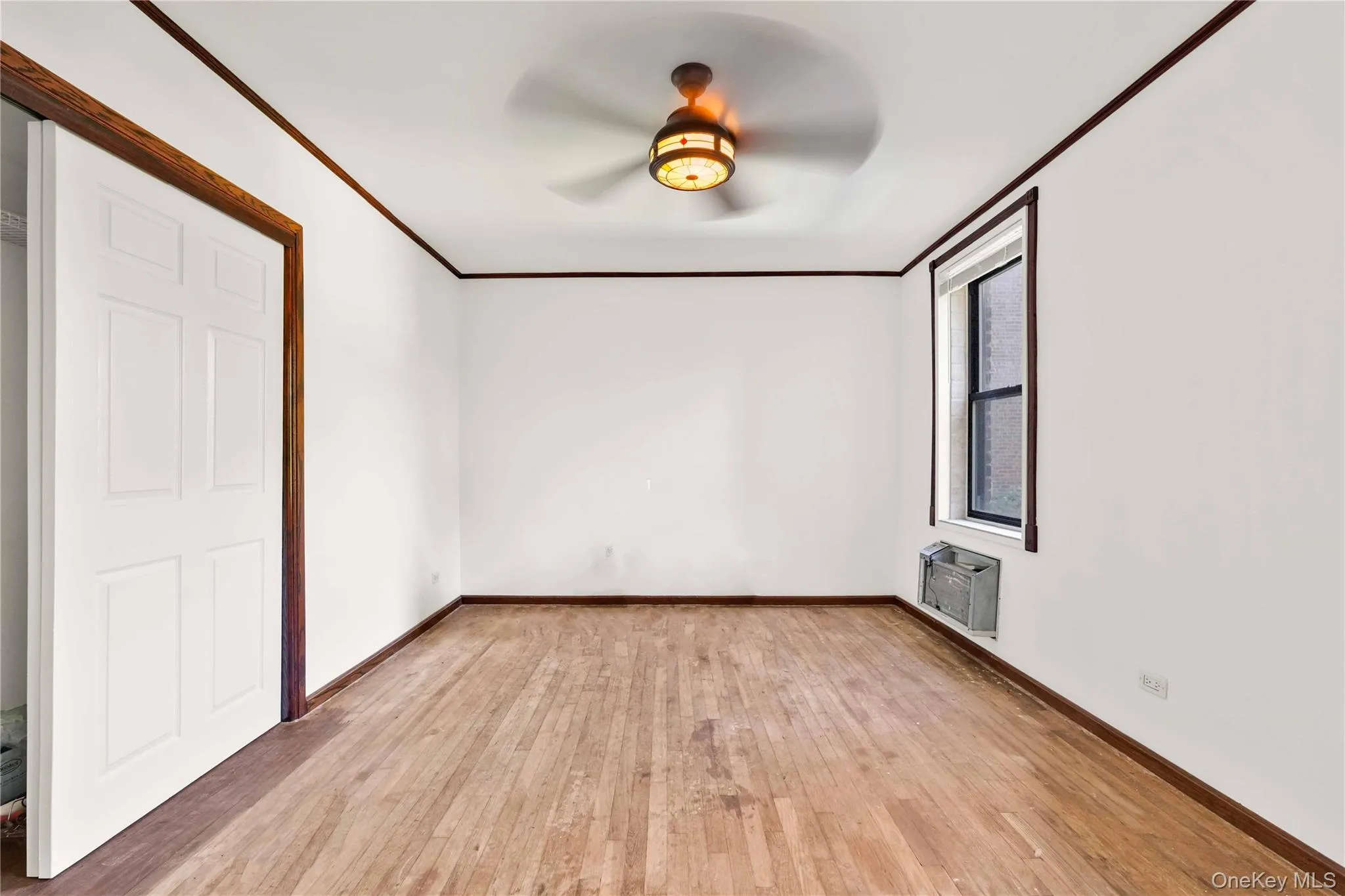 Unfurnished bedroom featuring crown molding, light wood-style flooring, and a ceiling fan Unfurnished bedroom featuring crown molding, light wood-style flooring, and a ceiling fan