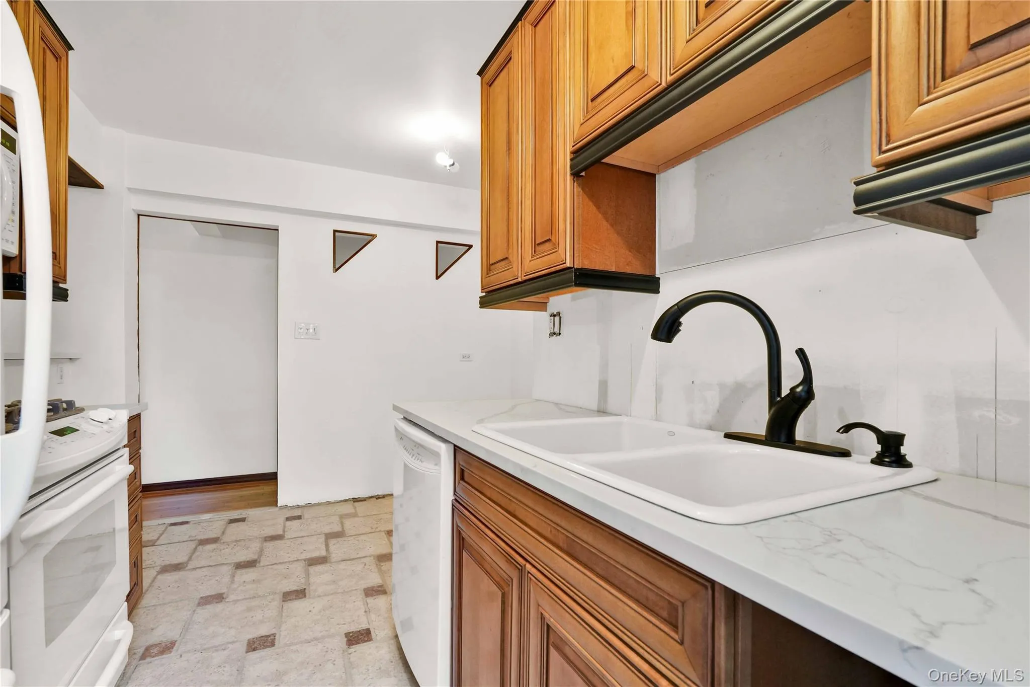 Kitchen with brown cabinetry and white appliances Kitchen with brown cabinetry and white appliances