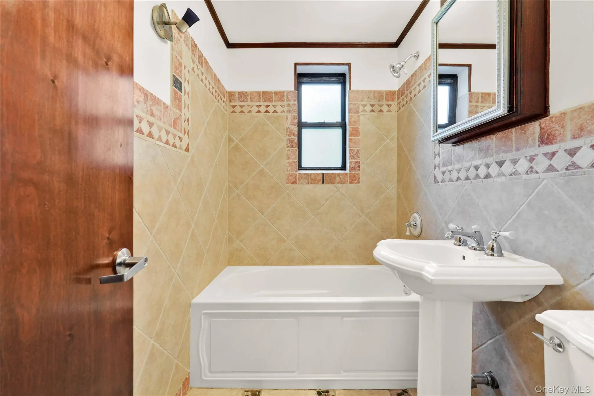 Full bathroom featuring tile walls, shower combination, and crown molding Full bathroom featuring tile walls, shower combination, and crown molding
