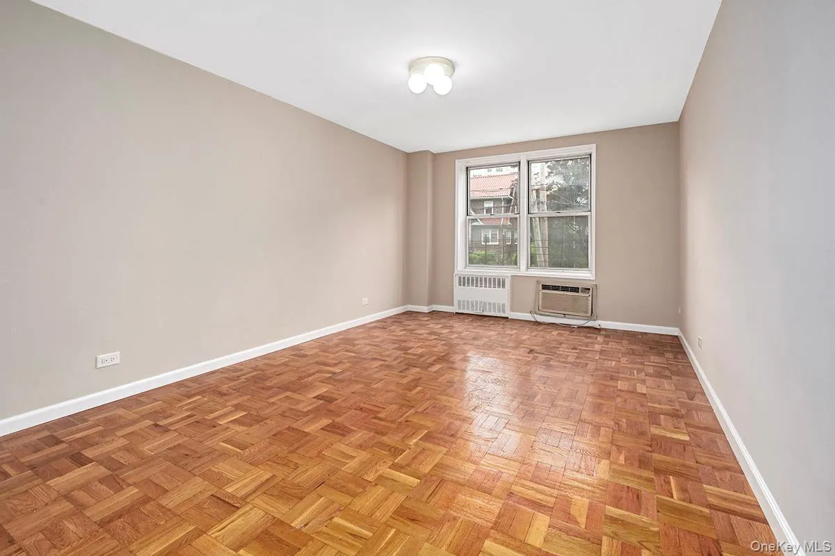 Unfurnished room featuring radiator and a wall mounted AC Unfurnished room featuring radiator and a wall mounted AC