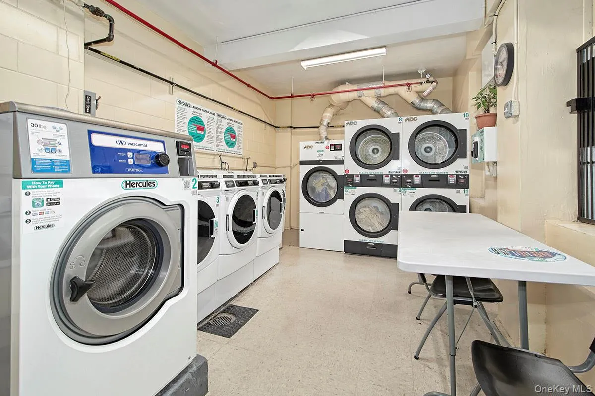 Communal laundry room featuring light flooring and washing machine and clothes dryer Communal laundry room featuring light flooring and washing machine and clothes dryer
