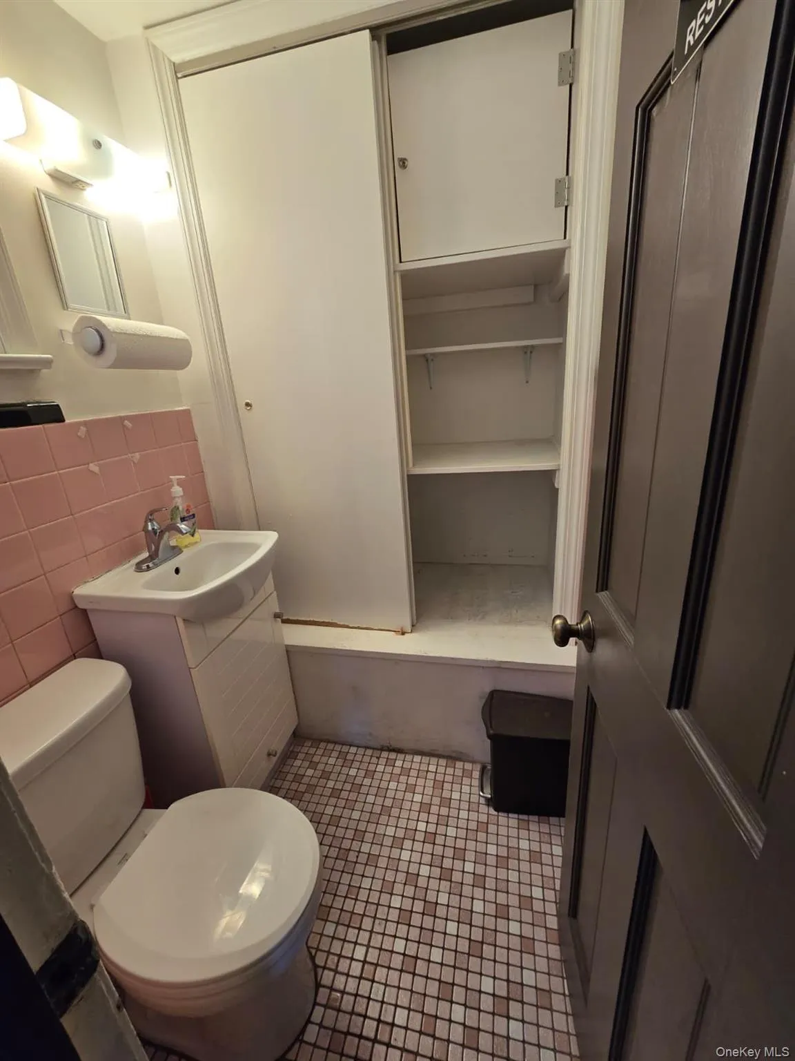 Bathroom featuring dark tile patterned floors, tile walls, and vanity Bathroom featuring dark tile patterned floors, tile walls, and vanity