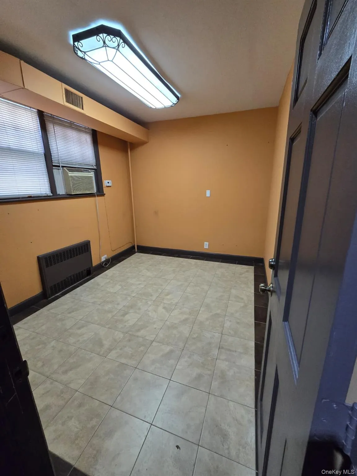 Spare room featuring radiator heating unit and light tile patterned floors Spare room featuring radiator heating unit and light tile patterned floors