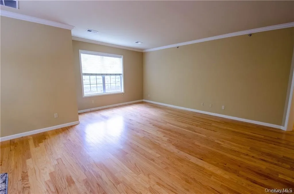 Empty room featuring ornamental molding and light wood-type flooring Empty room featuring ornamental molding and light wood-type flooring