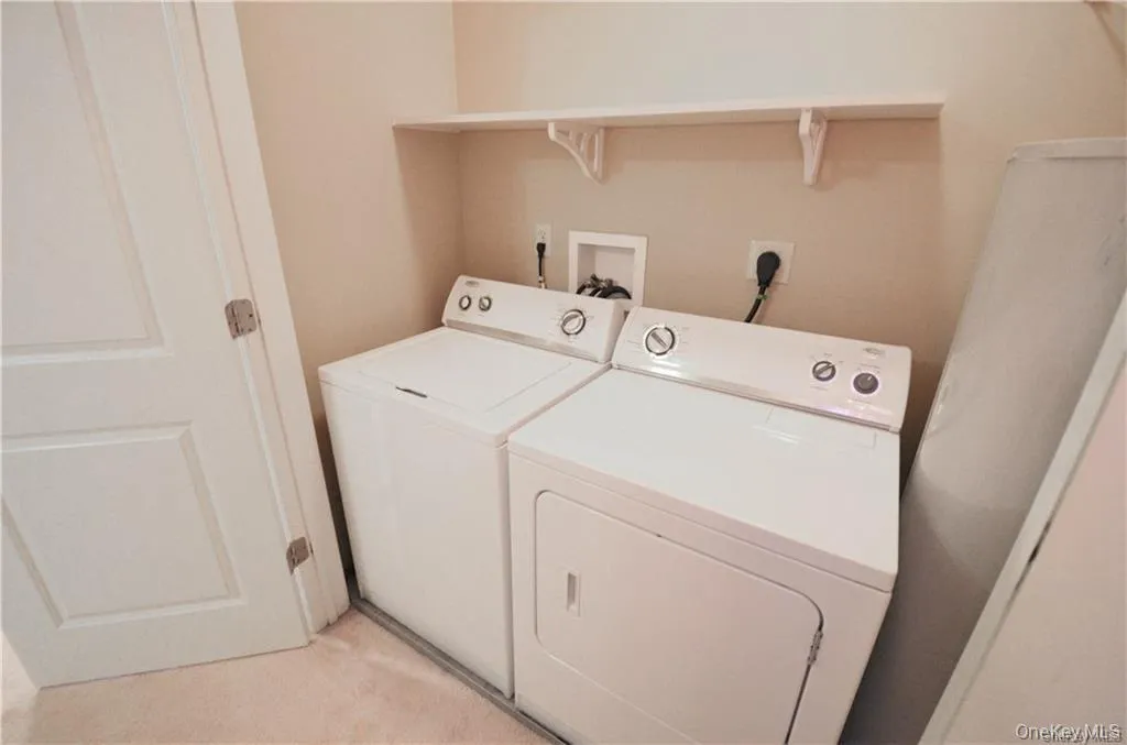 Laundry area featuring independent washer and dryer and light carpet Laundry area featuring independent washer and dryer and light carpet