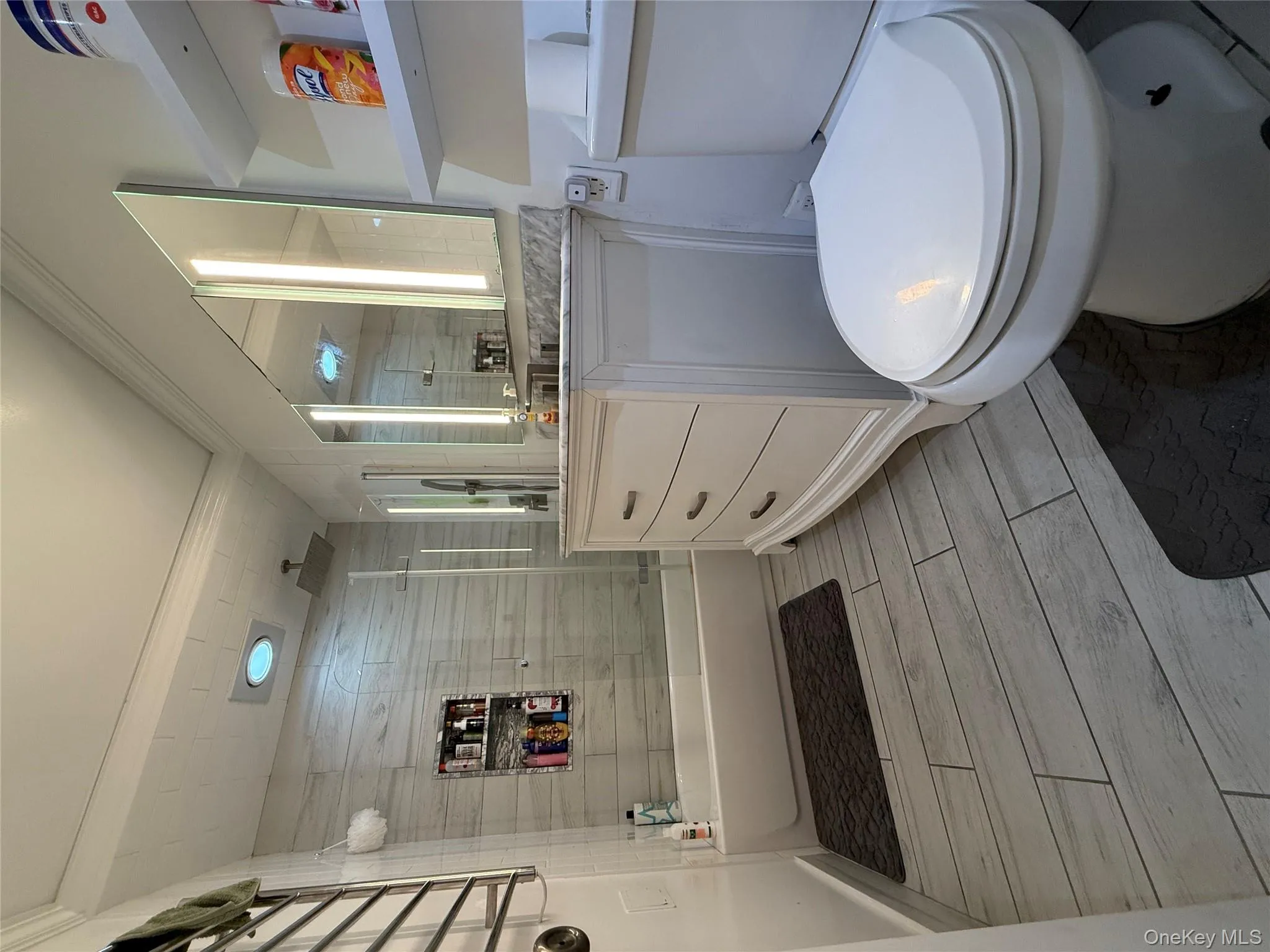 Full bathroom with a combined bath / shower with rainfall shower, vanity, wood tiled floors, and crown molding Full bathroom with a combined bath / shower with rainfall shower, vanity, wood tiled floors, and crown molding