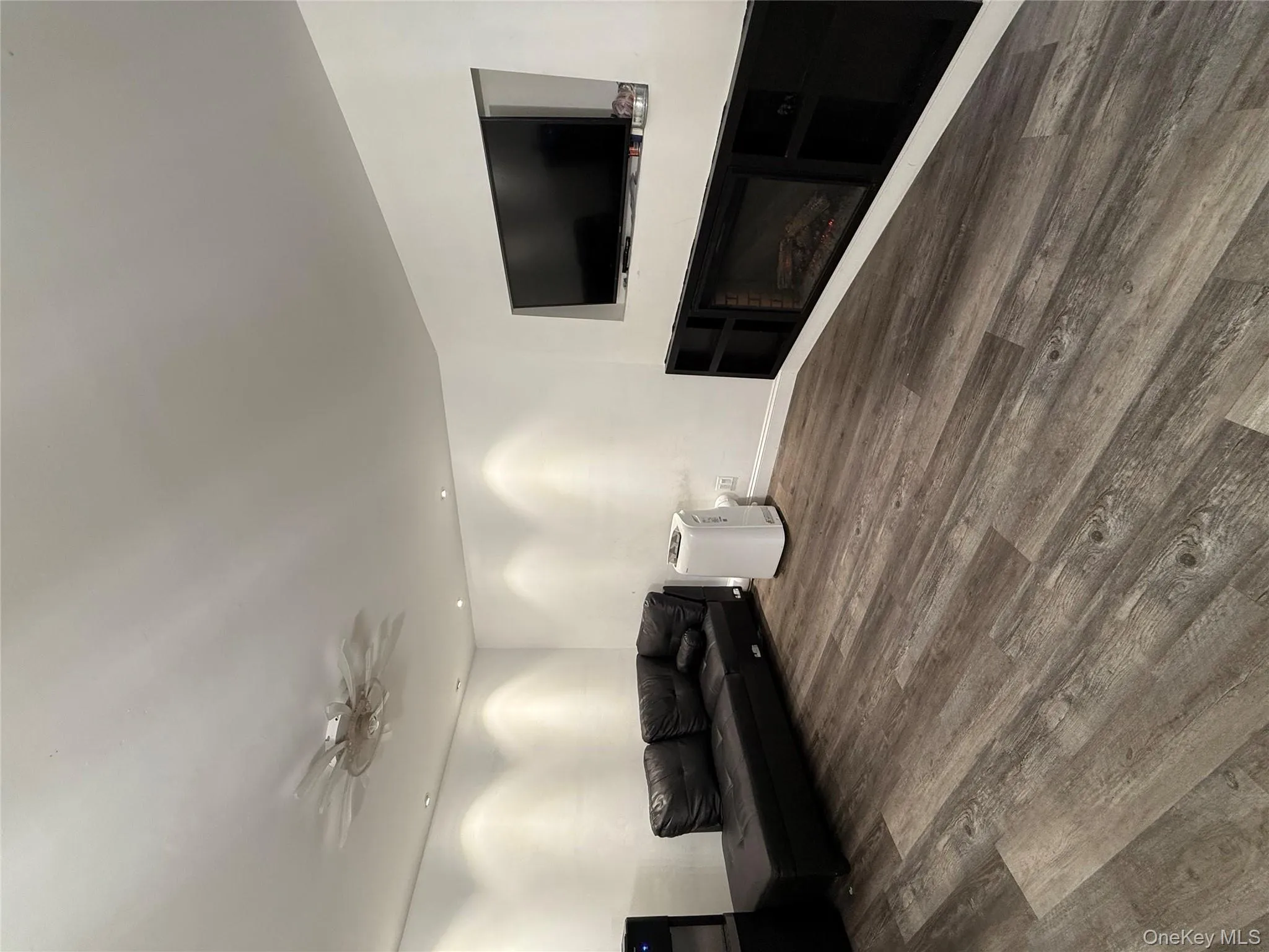 Living room featuring wood finished floors, a ceiling fan, a fireplace, and recessed lighting Living room featuring wood finished floors, a ceiling fan, a fireplace, and recessed lighting
