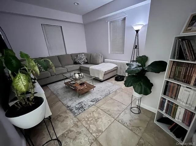 Living room with radiator heating unit and baseboards Living room with radiator heating unit and baseboards