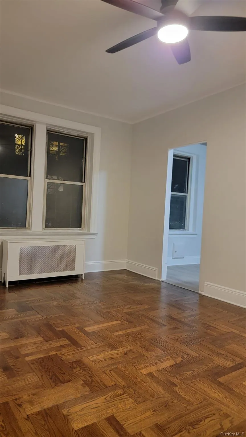 Unfurnished room with radiator and ceiling fan Unfurnished room with radiator and ceiling fan