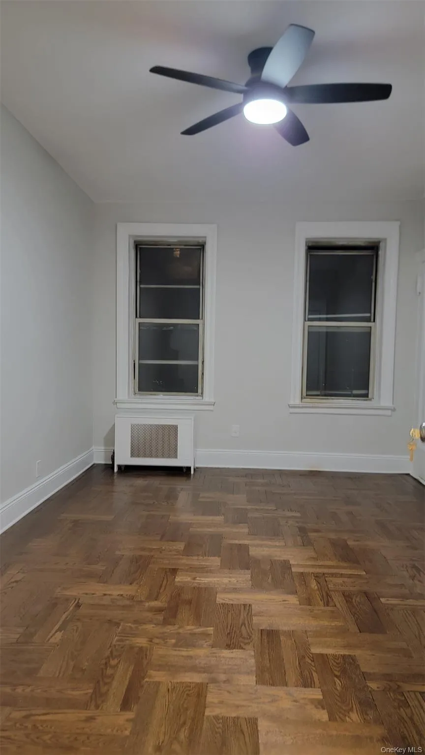 Unfurnished room with radiator and a ceiling fan Unfurnished room with radiator and a ceiling fan