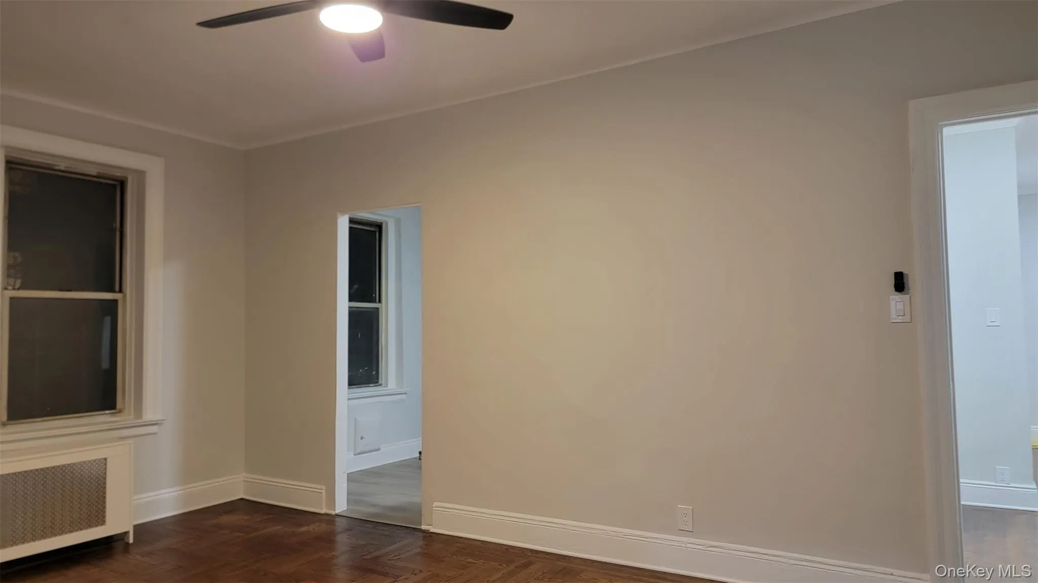 Unfurnished room featuring radiator and ceiling fan Unfurnished room featuring radiator and ceiling fan