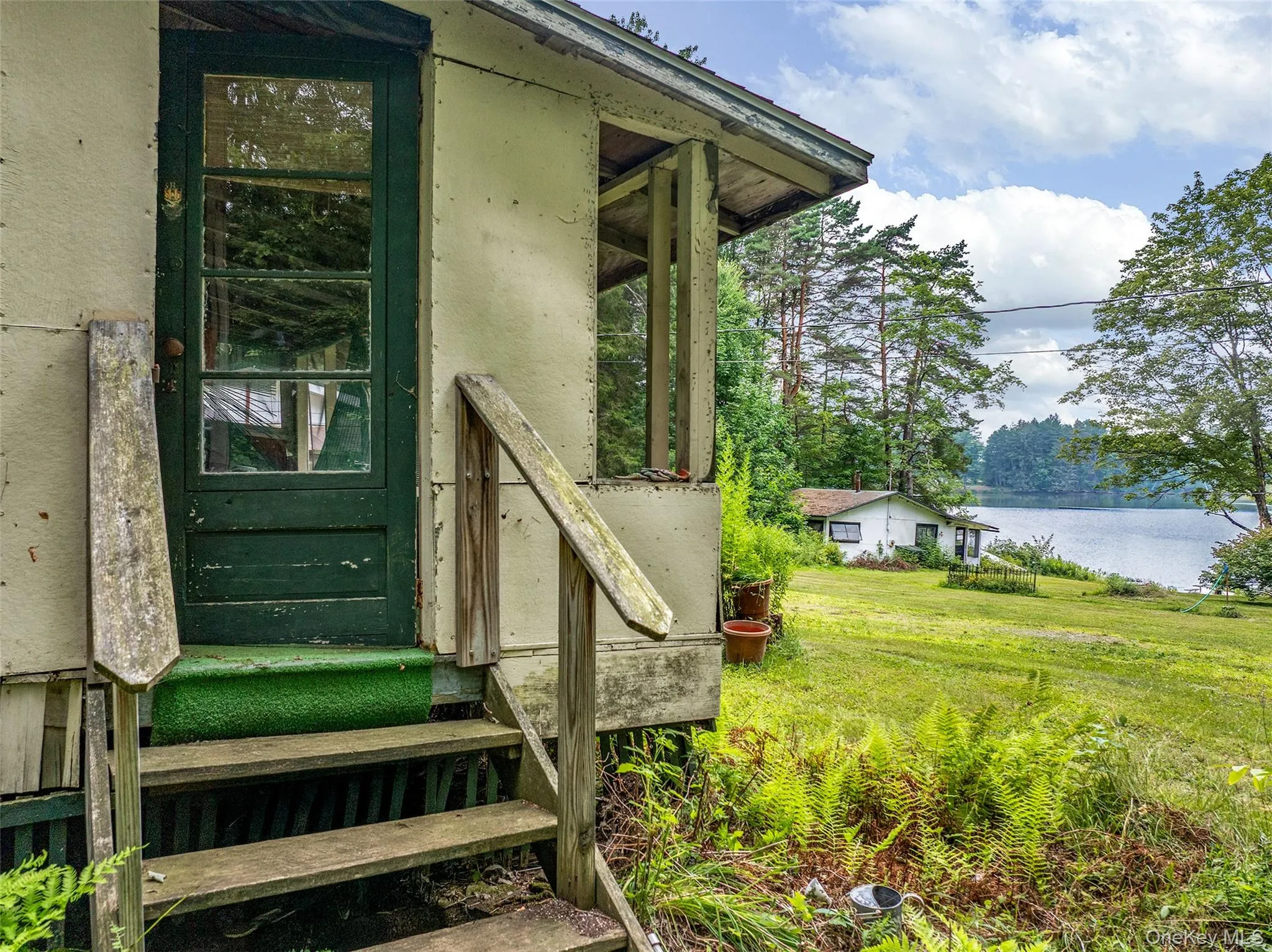 Property entrance with a water view and a lawn Property entrance with a water view and a lawn