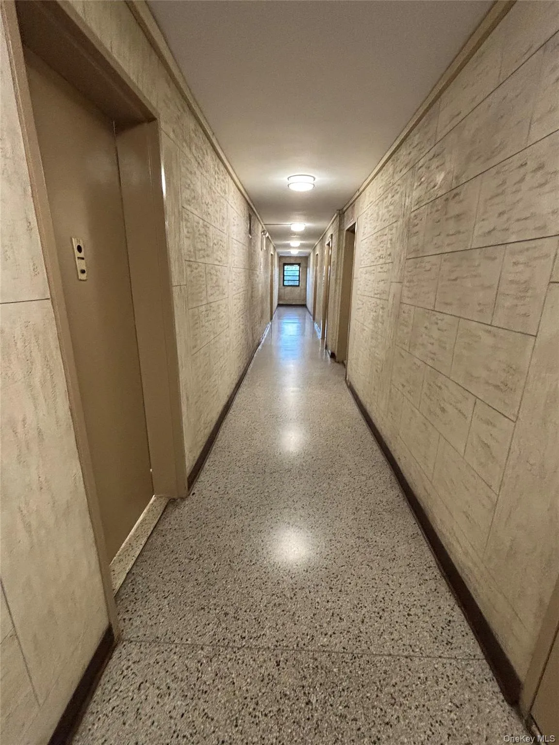 Corridor featuring elevator and speckle patterned floor Corridor featuring elevator and speckle patterned floor