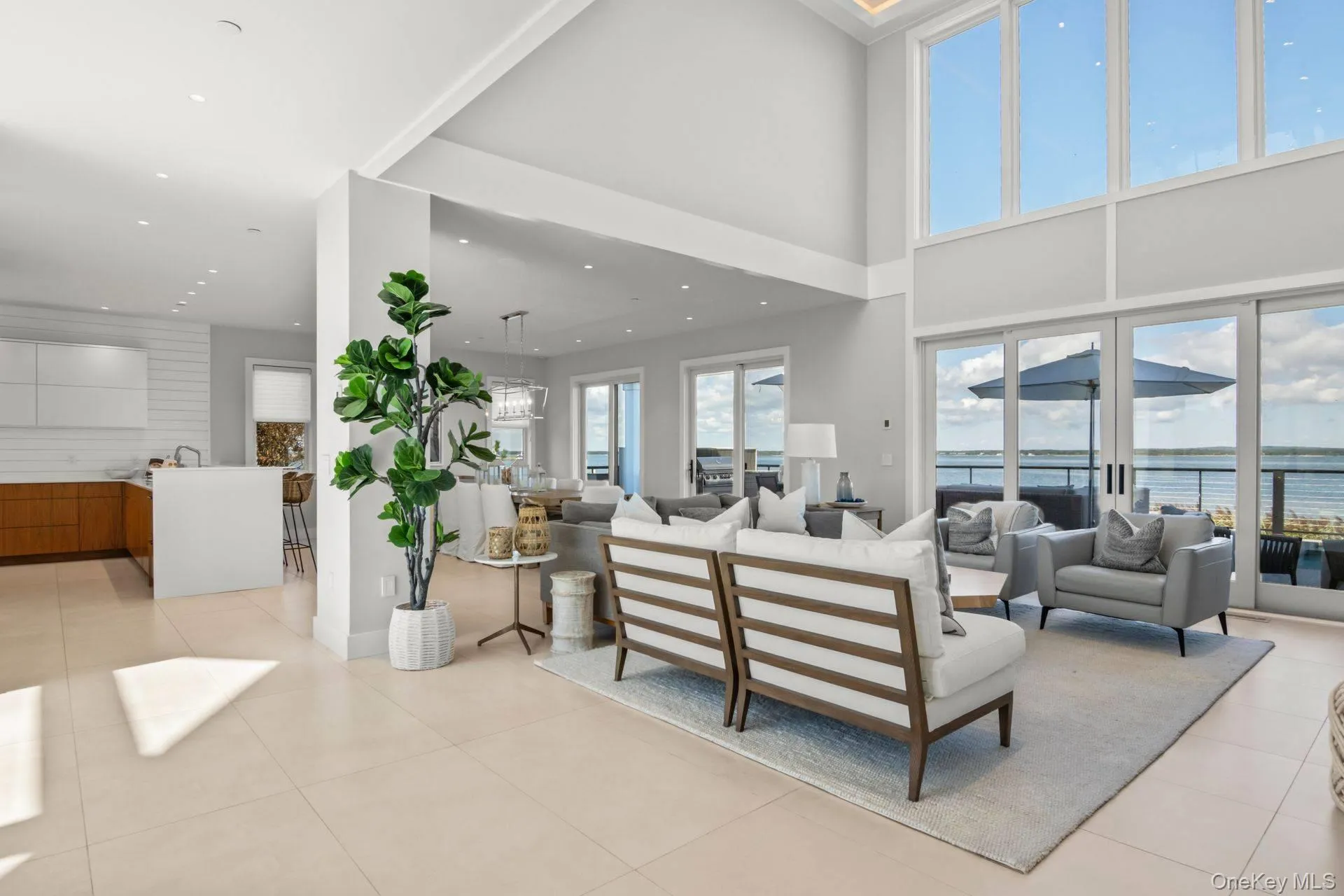 Living area featuring tile patterned floors, healthy amount of natural light, a water view, and recessed lighting Living area featuring tile patterned floors, healthy amount of natural light, a water view, and recessed lighting