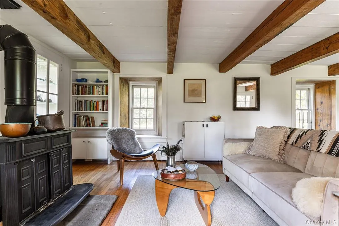 Stone House -Living room with beam ceiling, wood stove and hardwood floors Stone House -Living room with beam ceiling, wood stove and hardwood floors