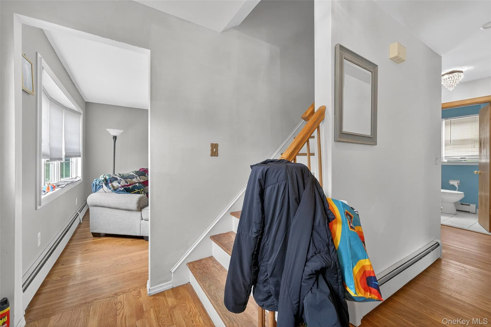 Stairway featuring plenty of natural light, a baseboard heating unit, and wood finished floors Stairway featuring plenty of natural light, a baseboard heating unit, and wood finished floors