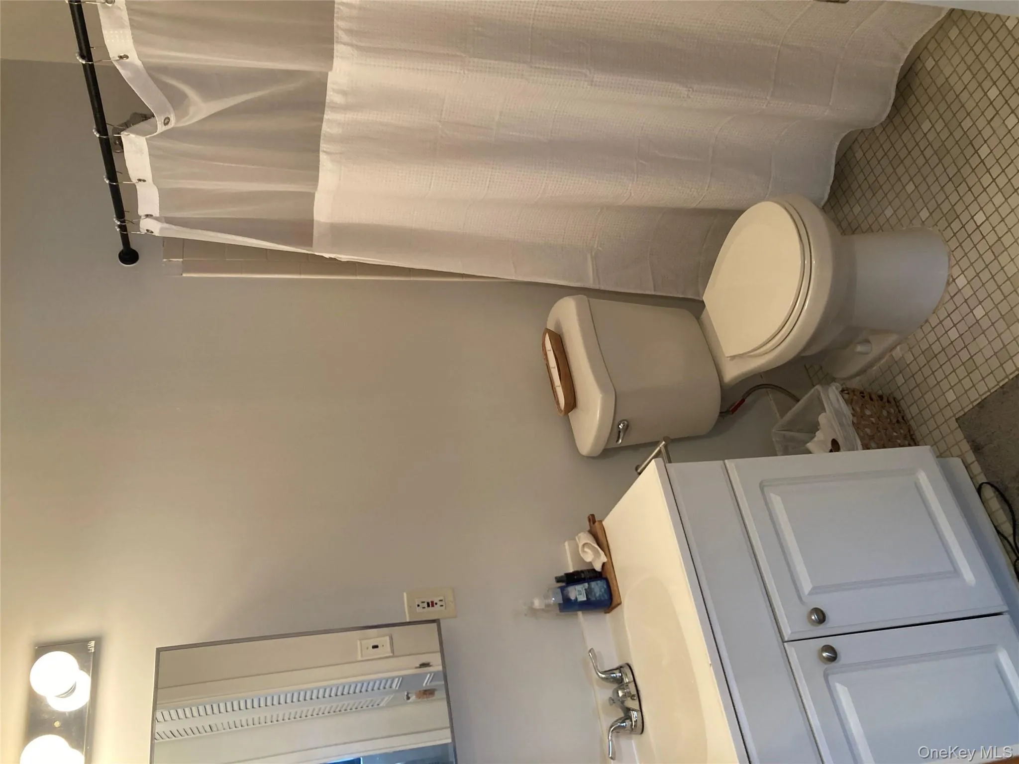 Full bath featuring vanity, light tile patterned floors, and a shower with shower curtain Full bath featuring vanity, light tile patterned floors, and a shower with shower curtain