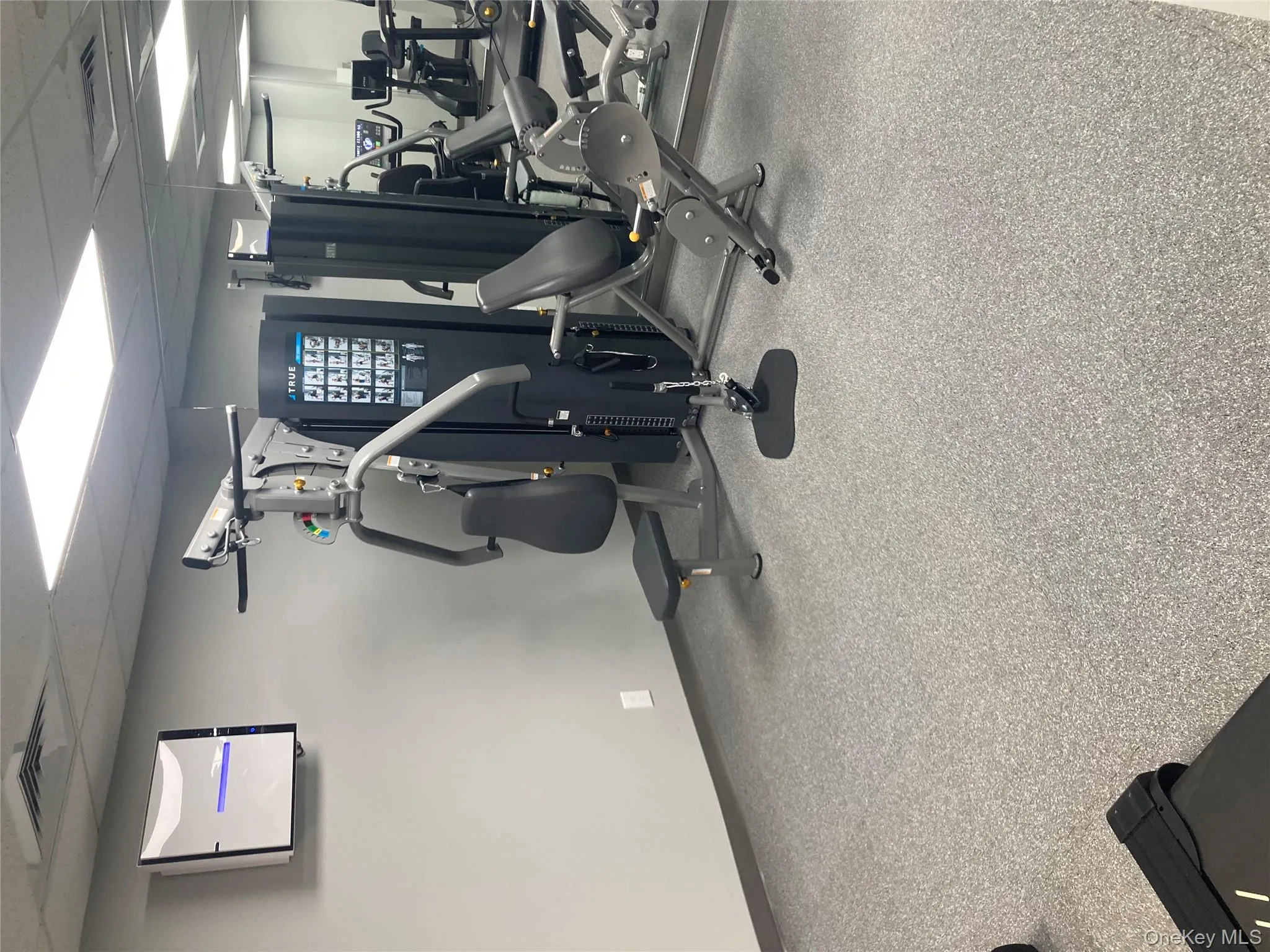 Exercise room with a drop ceiling and baseboards Exercise room with a drop ceiling and baseboards