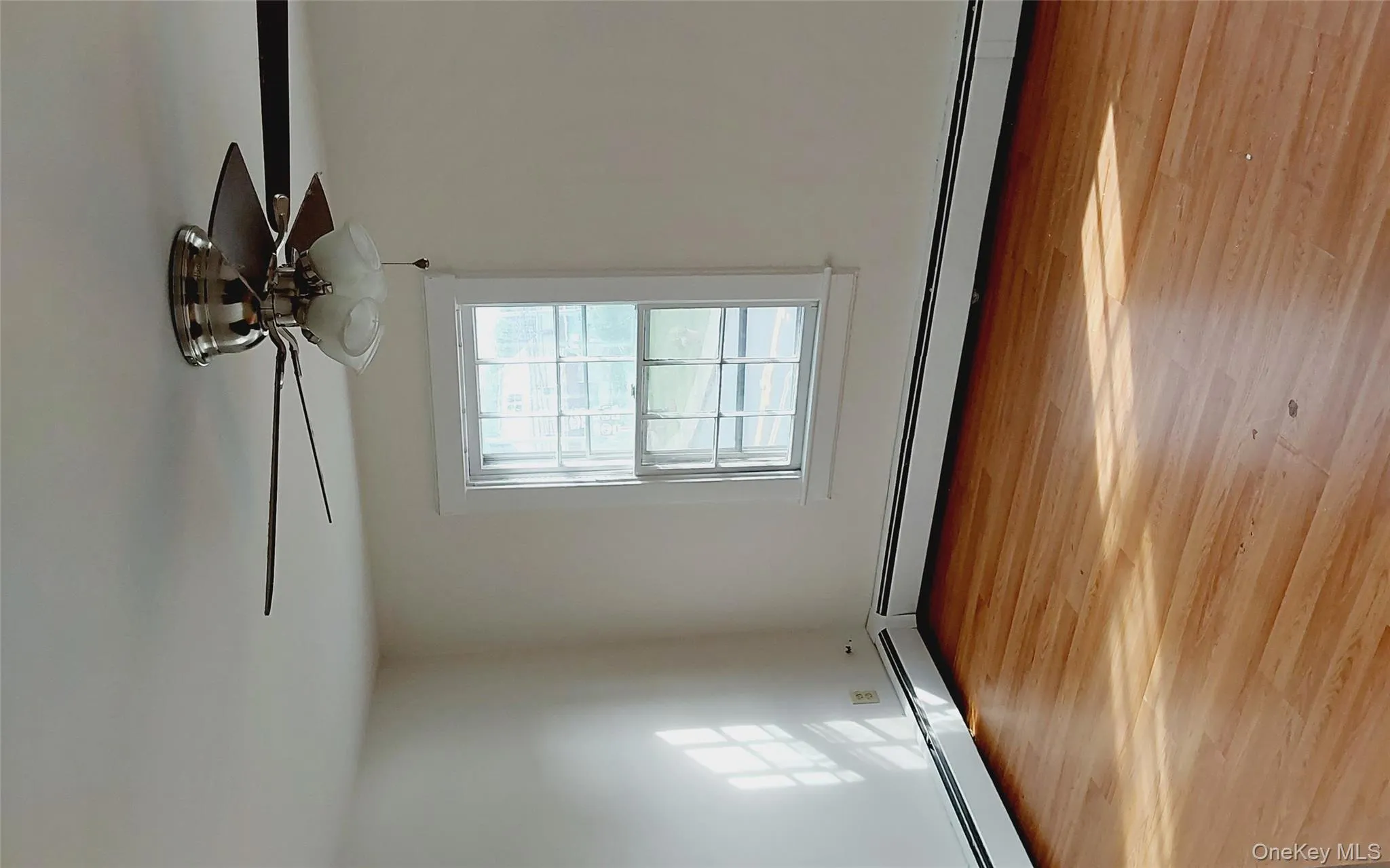 Unfurnished room featuring light wood-type flooring and a baseboard heating unit Unfurnished room featuring light wood-type flooring and a baseboard heating unit